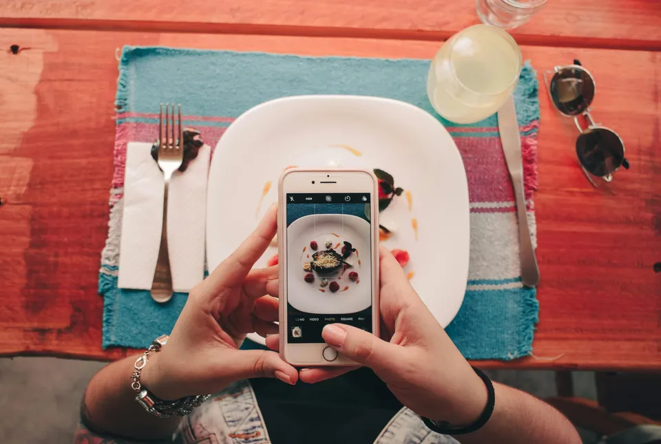 A guest photographing their meal with a smartphone